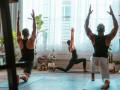 A group of people holding a yoga pose while indoors 