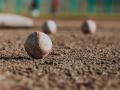 Baseballs in the dirt of a baseball field
