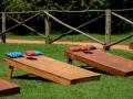 A line of cornhole boards and beanbags