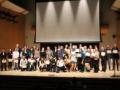 A large group of scholarship recipients posing on stage at the Scholarship Showcase
