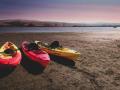 three kayaks on the beach next to the ocean