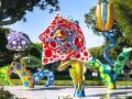 Three colorful outdoor art sculptures surrounded by greenery 