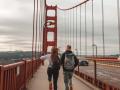 A pair of people skipping while crossing the Golden Gate Bridge
