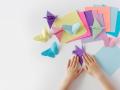 Someone folding multicolored origami butterflies 