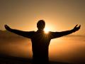 the silhouette of a person in front of an orange sunset