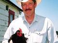 Scott Gerber wearing a cowboy hat and holding a chicken