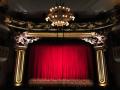An elegant theater stage with a red curtain