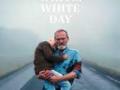 Movie poster for A White, White Day featuring an older bearded man carrying someone in his arms while walking on a foggy road