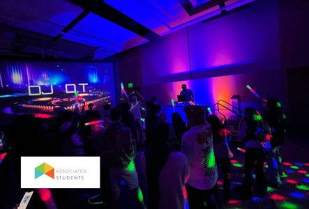 Associated Students Silent Disco A DJ performing and people dancing in a colorfully lit room