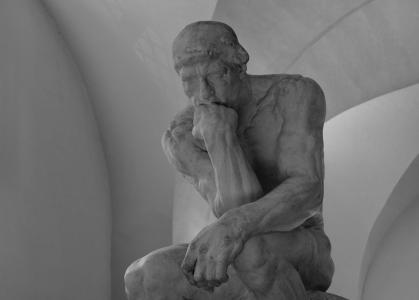 A carved statue of a person resting their head on the fist