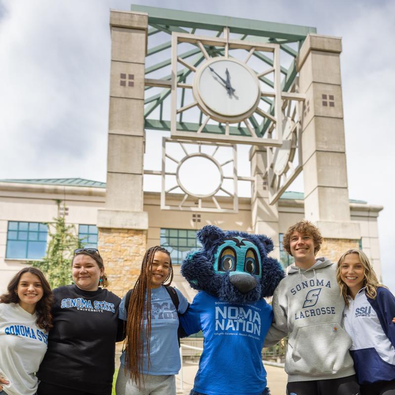 Students taking a photo with Lobo outside the library