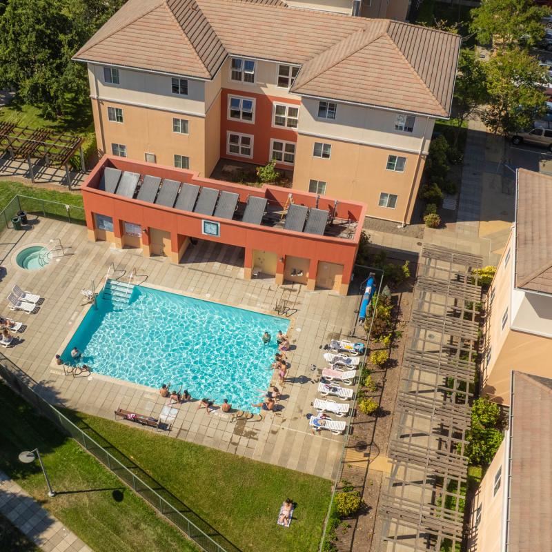 Aerial of beaujolais housing village and pool with people around the pool
