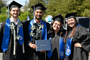Four graduates in academic regalia