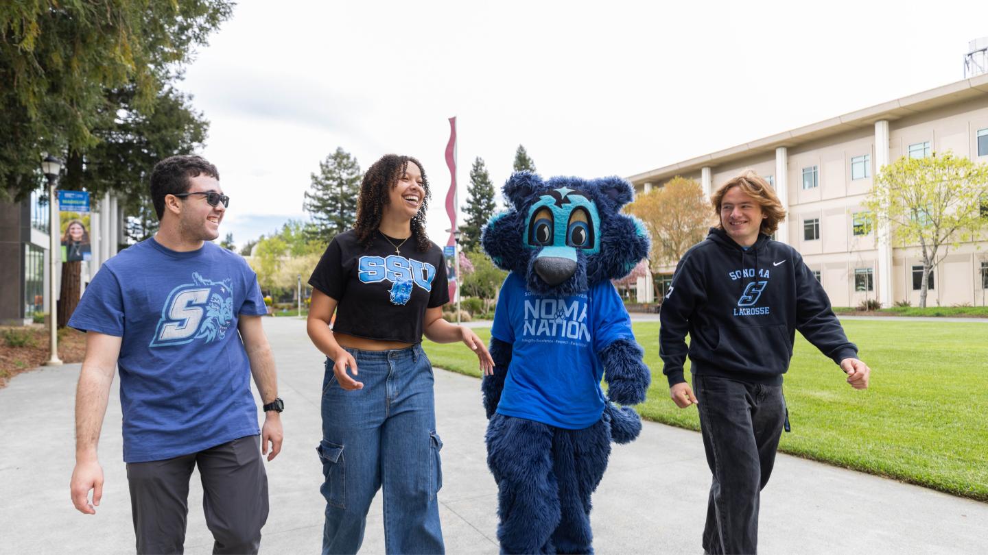 Three students walking with Lobo